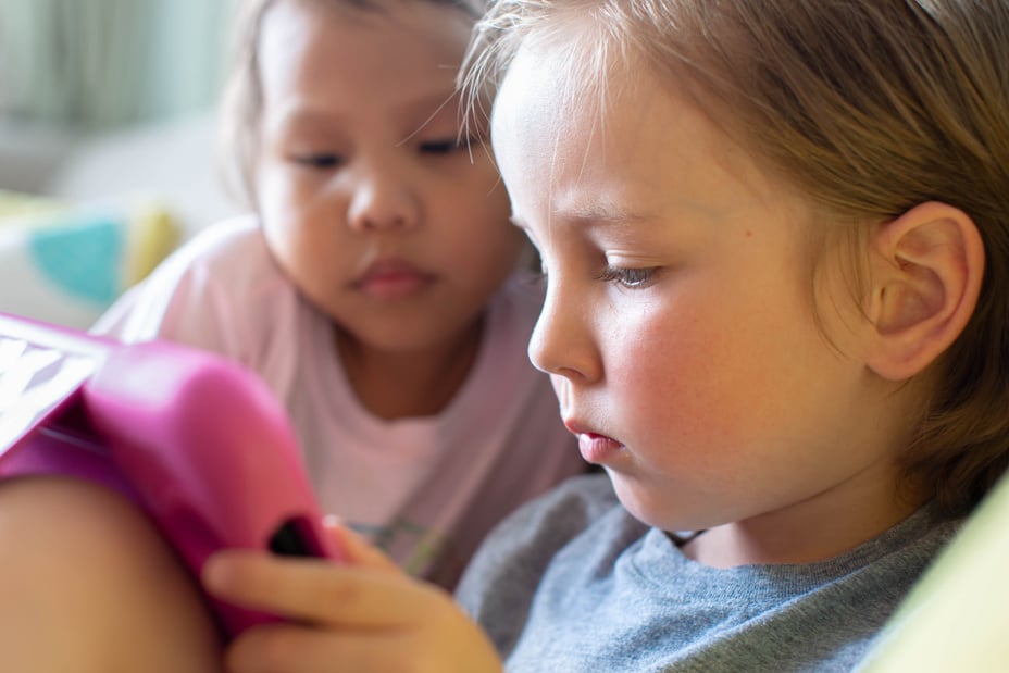 Kids watching tv on a tablet. Children learning online.